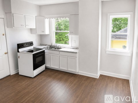 A kitchen with white cabinets and a black stove top oven.