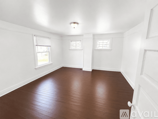 A room with brown flooring and white walls.