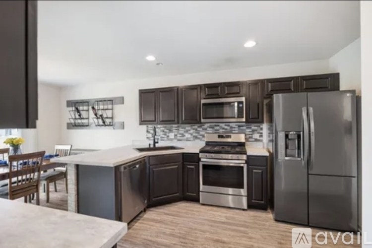 A kitchen with dark brown cabinets and stainless steel appliances.
