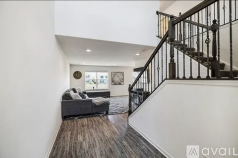 A living room with a couch and a staircase.