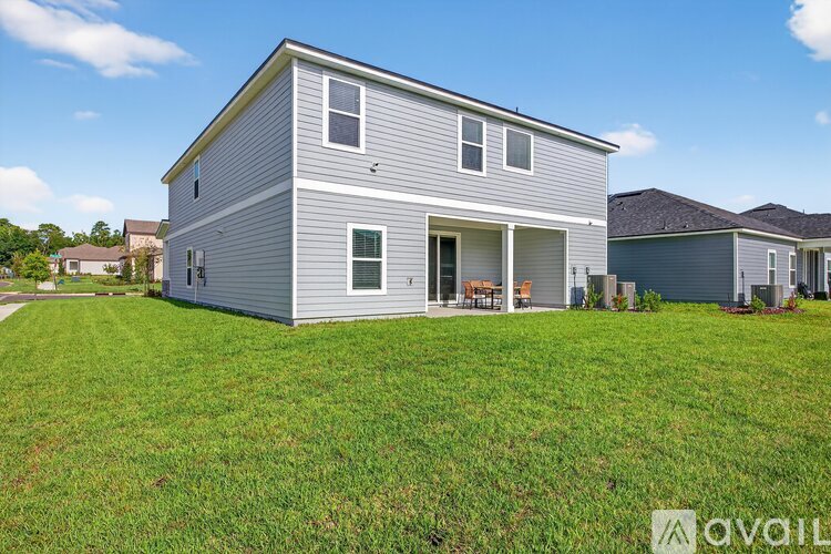 A house with a grey exterior and a green lawn in front.