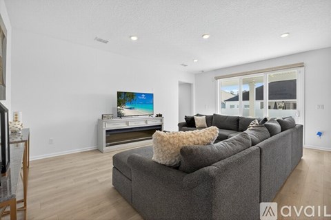 A modern living room with a grey couch and a flat screen TV.