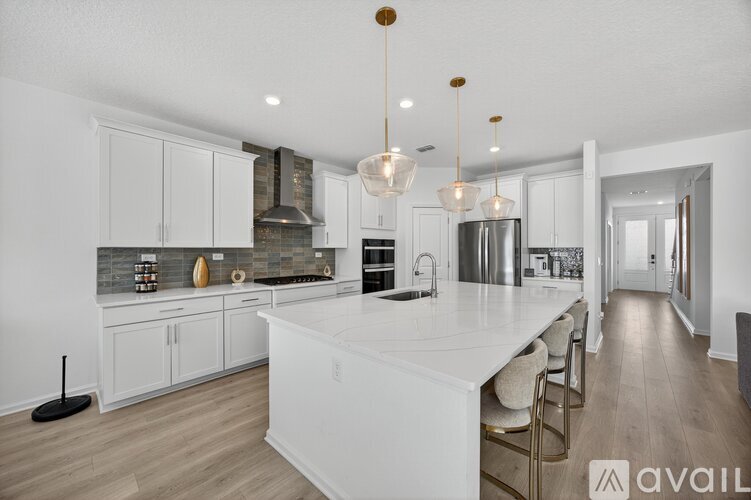 A modern kitchen with white cabinets and a large island.
