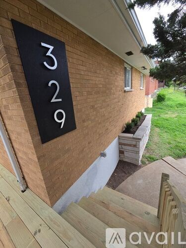 A black house number sign on a brick wall.