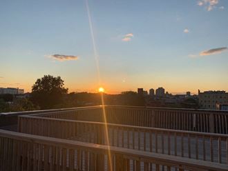 a view of the sun setting over the city from a balcony