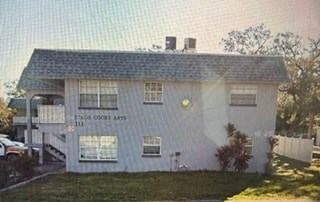 A white building with a sign that says "Eagle Court Apartments".