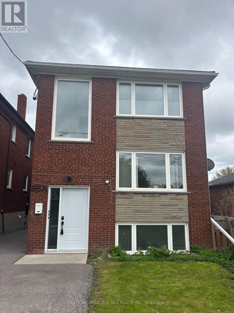 A two-story brick house with a white door and windows.