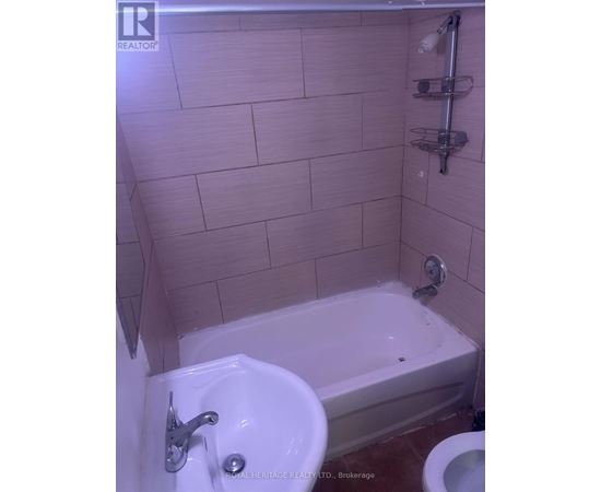 A white sink in a bathroom with a white bathtub and a white toilet.