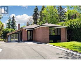 A modern house with a brick exterior and a large driveway.