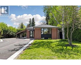 A house with a brick facade and a large front yard.