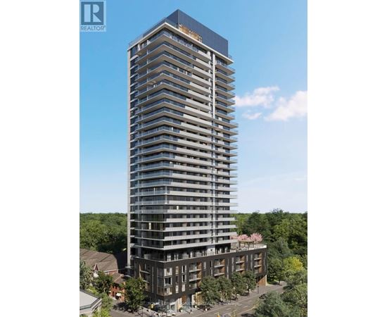 A tall building with many windows and balconies is surrounded by trees.