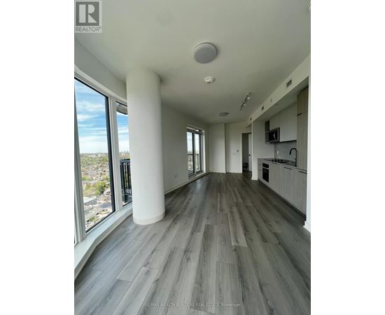A spacious room with a large window overlooking a cityscape.