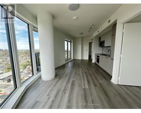 A spacious living room with a view of the cityscape outside the large windows.