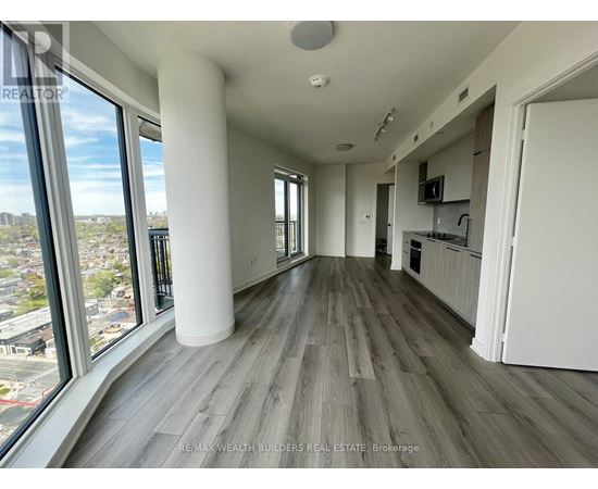 A spacious living room with a view of the cityscape outside the large windows.