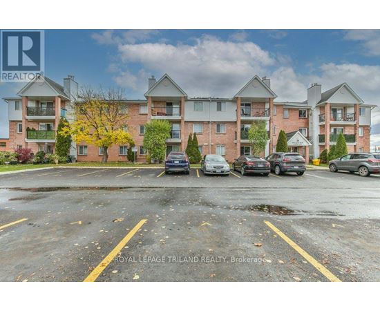 A parking lot in front of a multi-story apartment building.