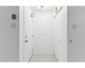 A white door with a gold handle is open.