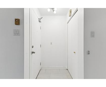 A white door with a gold handle is open.