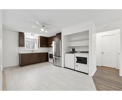 A kitchen with white appliances and brown cabinin