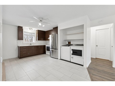 A kitchen with white appliances and brown cabinin