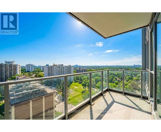 A balcony with a view of the cityscape and greenery.