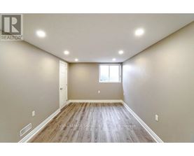 A spacious room with wooden flooring and a window.