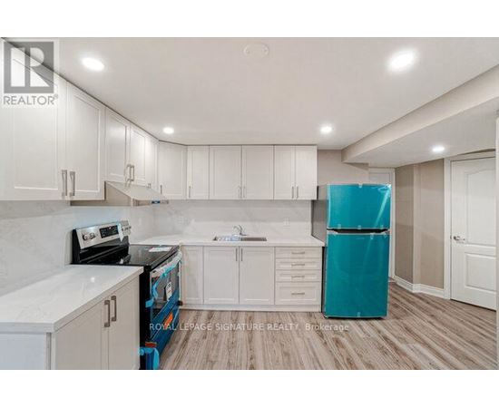 A kitchen with white cabinets and a blue refrigerator.