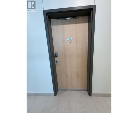 A brown door with a number 103 on it.