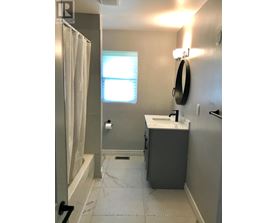 A bathroom with a sink, mirror, and bathtub.