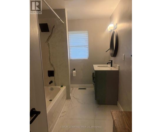 A bathroom with a sink, mirror, and bathtub.