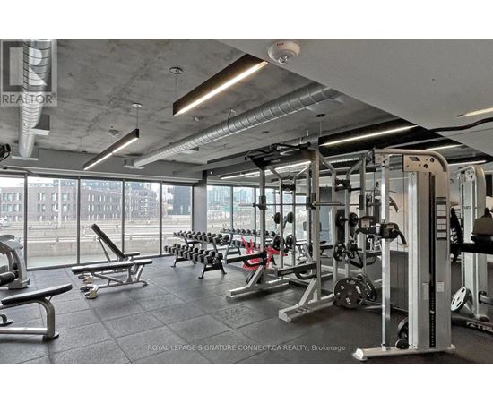 A gym with a variety of equipment including weights and benches.