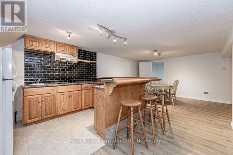 A kitchen with wooden cabinets and a bar area.