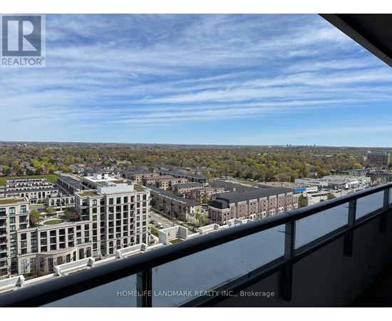 A view from a balcony overlooking a cityscape with buildings and trees.