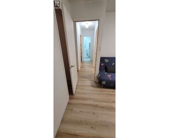 A long hallway with wooden floors and white walls.