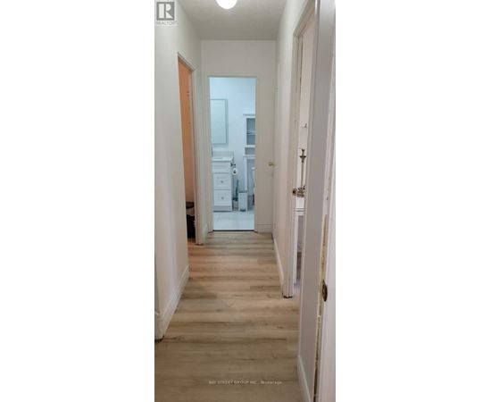A hallway with wooden floors and white walls.