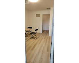 A room with a wooden floor and a table with two chairs.
