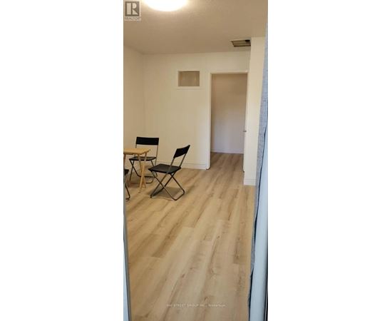 A room with a wooden floor and a table with two chairs.