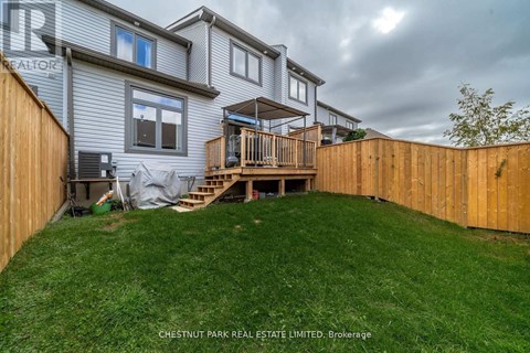A house with a deck and a fence in the yard.