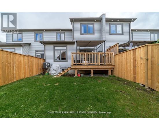 A house with a wooden fence and a deck in the backyard.