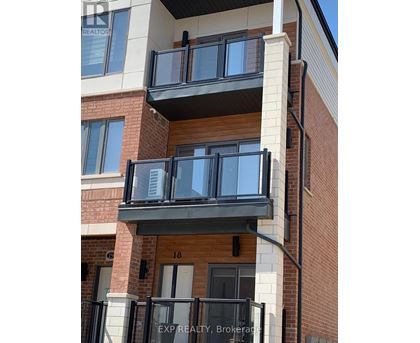 A balcony with black railings and a glass door is attached to a brick building.
