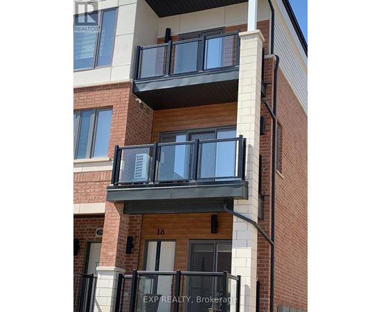 A balcony with black railings and a glass door is attached to a brick building.
