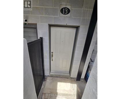 A white door with a black handle is on the 13th floor of a building.