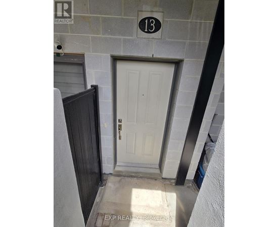 A white door with a black handle is on the 13th floor of a building.