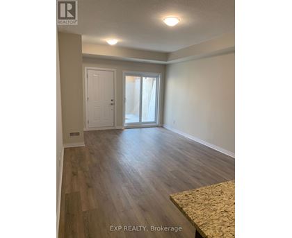A room with wooden flooring and a sliding glass door.