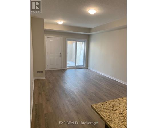 A room with wooden flooring and a sliding glass door.