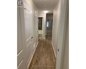 A hallway with white doors and wood floors.