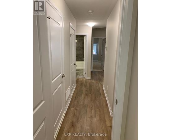 A hallway with white doors and wood floors.