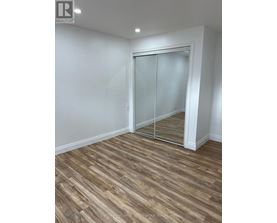 A room with a wooden floor and a sliding glass door.