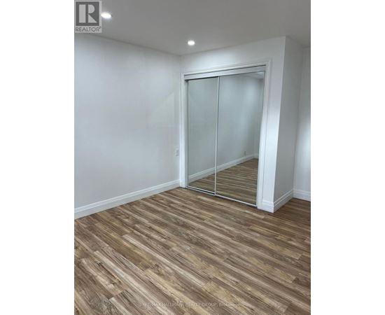 A room with a wooden floor and a sliding glass door.
