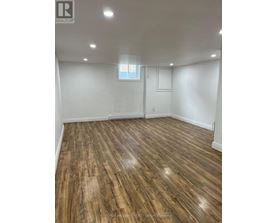 A room with wooden flooring and a window.
