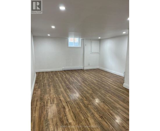 A room with wooden flooring and a window.